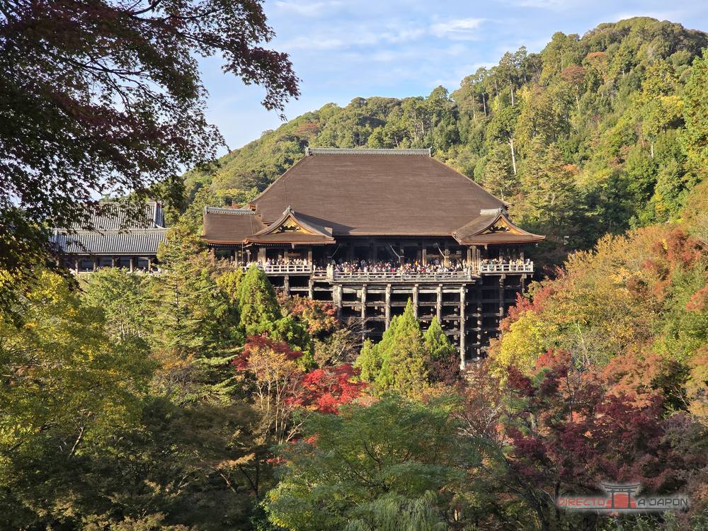 El Hondo de Kiyomizudera sobre sus pilares de madera en la ladera, rodeado de bosque y de árboles rojos y amarillos.