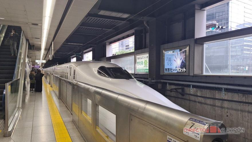 Shinkansen de morro alargado parado en un andén de estación, con la línea amarilla de seguridad en primer plano.