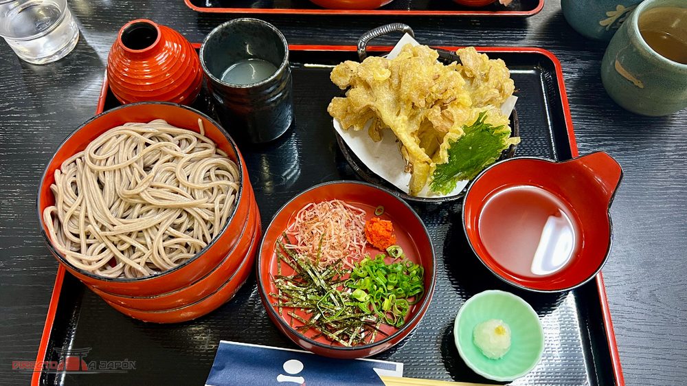 Warigo soba en platos apilados con condimentos y tempura de maitake en Ippuku, Izumo