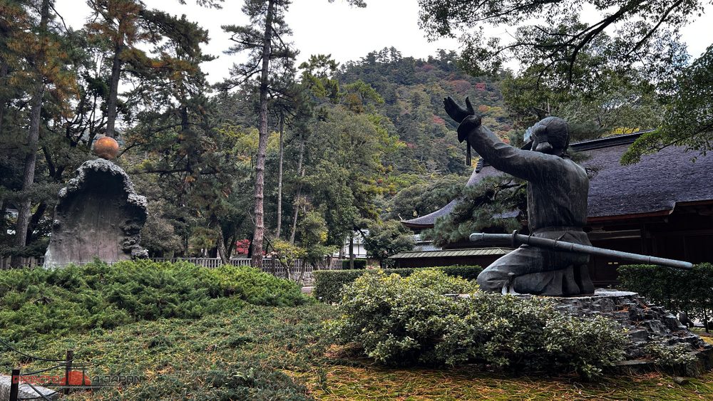 Estatua de Okuninushi frente a una esfera sobre una ola de piedra en Izumo Taisha