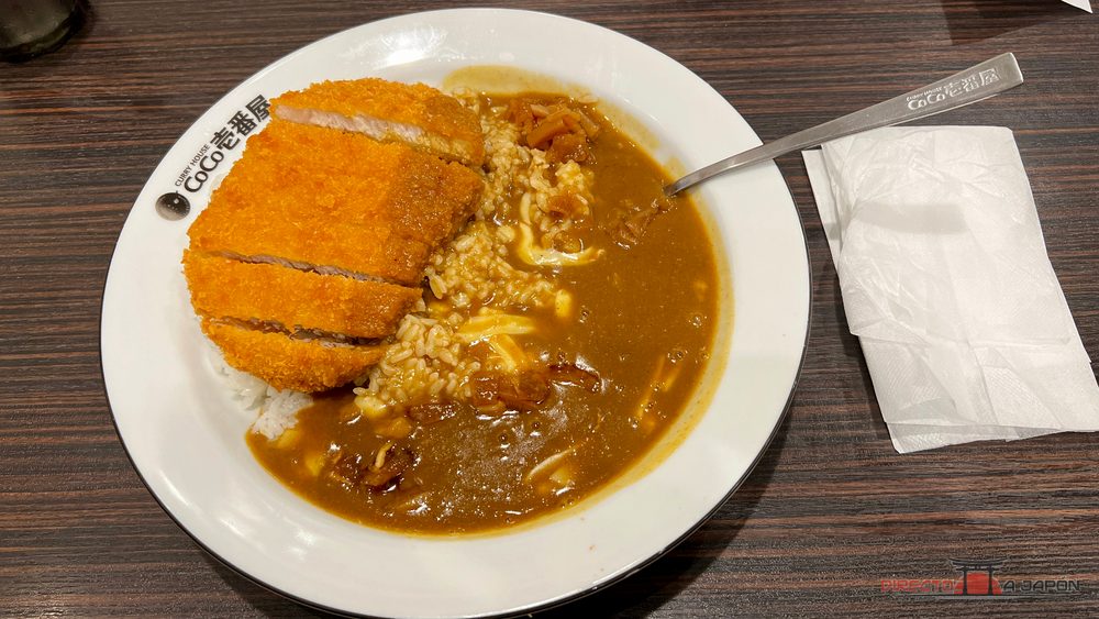 Plato de curry japonés con arroz y pieza empanada cortada en tiras.