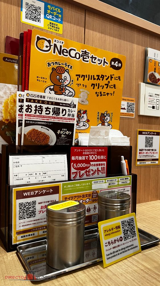 Organizador de mesa de CoCo Ichibanya con salsas, QR de pedido móvil e información de alérgenos.