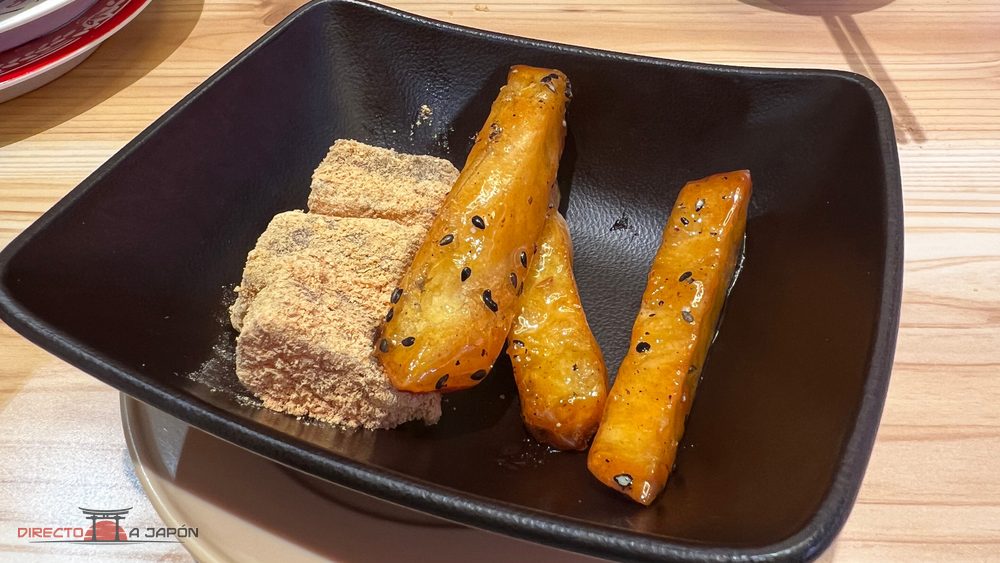 Postre con trozos de boniato glaseado con sésamo negro y cuadrados de warabimochi cubiertos de polvo