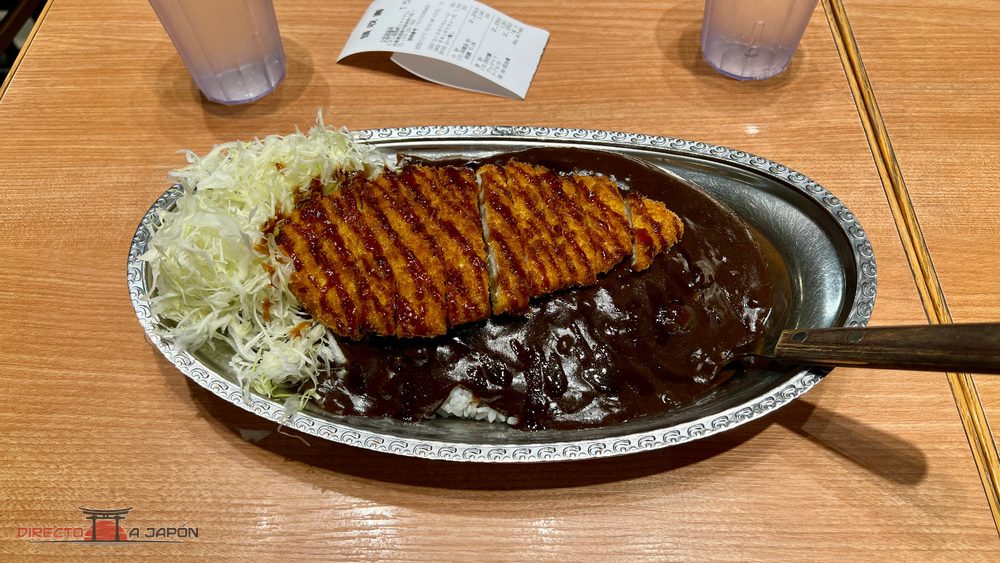 Plato de curry oscuro con empanado y col rallada en GoGo Curry de la estación de Himeji