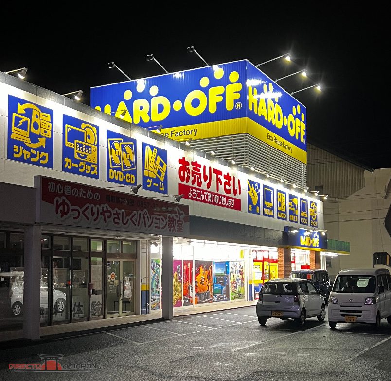 Fachada iluminada de HARD OFF con el nombre amarillo sobre fondo azul