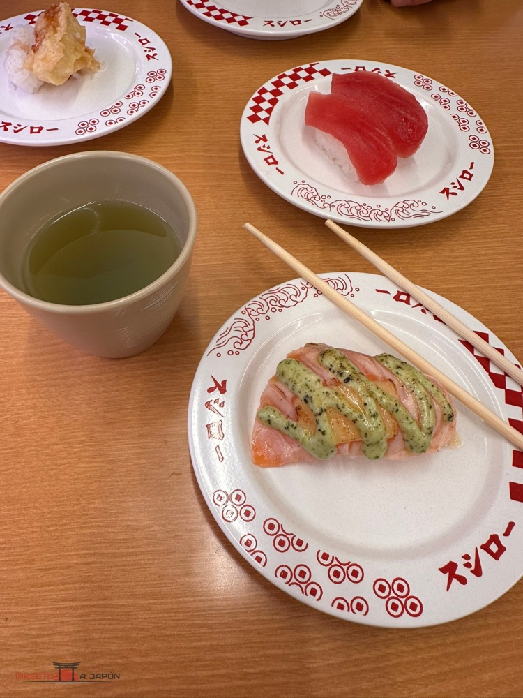 Platos de sushi y taza de té sobre una mesa de Sushiro