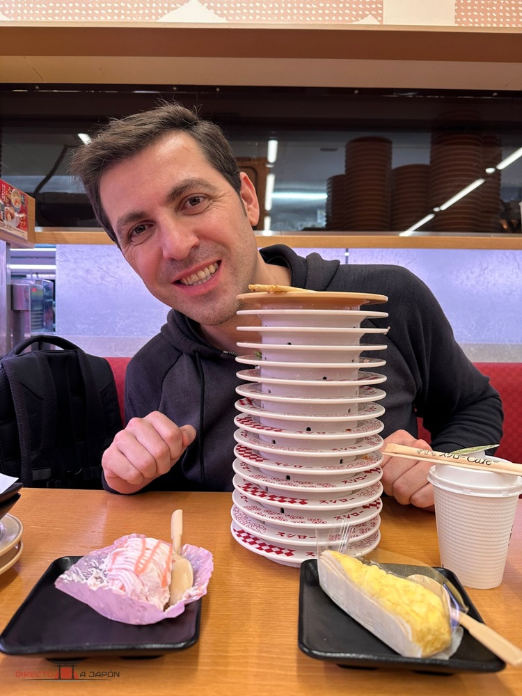 Edu junto a platos vacíos, dos postres y un café en Sushiro