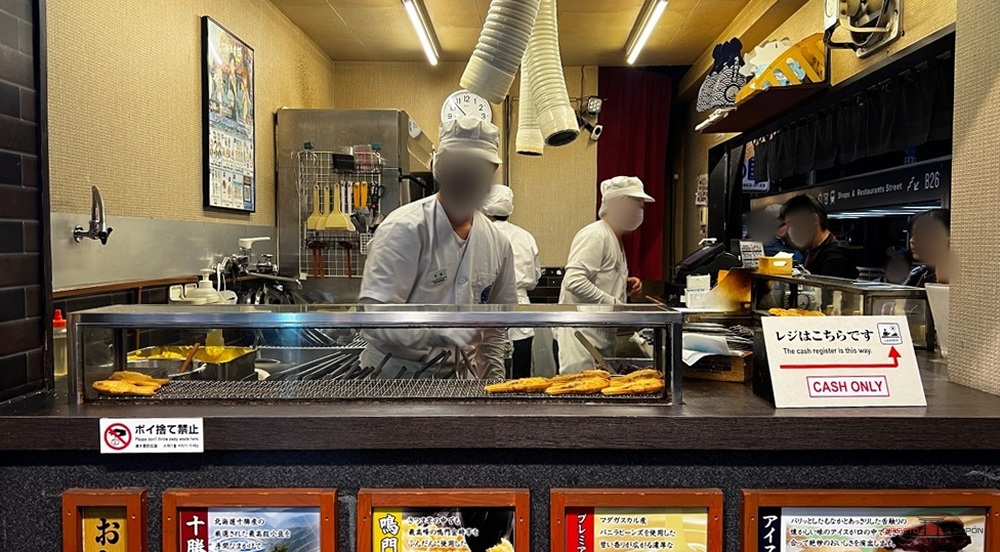 Mostrador de un puesto de taiyaki con los dulces recién hechos y el equipo de cocina detrás.