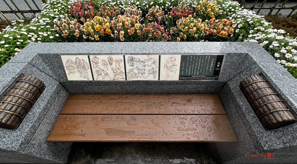 Banco de piedra con dibujos de luchadores de Hokusai