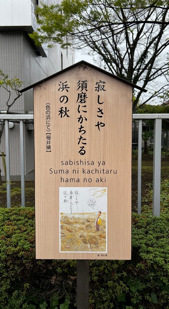 Cartel de madera con un haiku de Basho en japonés, en letras latinas y con una ilustración, en el paseo de haikus de Kiyosumi-Shirakawa.