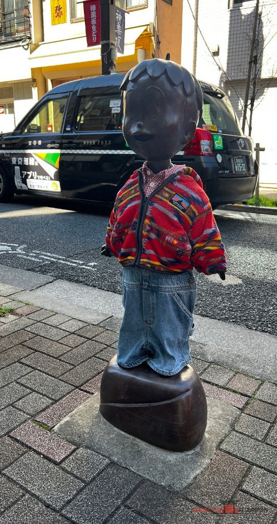 La estatua de Kobo-chan con chaqueta roja y pantalón vaquero en Kagurazaka