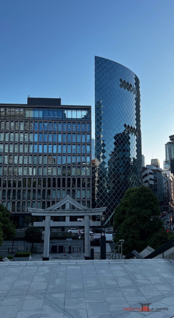 El torii de piedra y los edificios de Tokio desde el acceso de Hie.