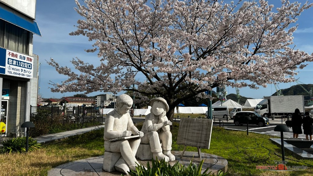 Figuras de piedra bajo un cerezo en nuestro paseo por Onomichi.