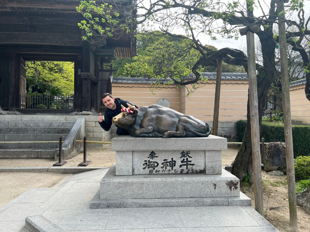 Edu junto a una estatua de buey shingyu en Dazaifu Tenmangu