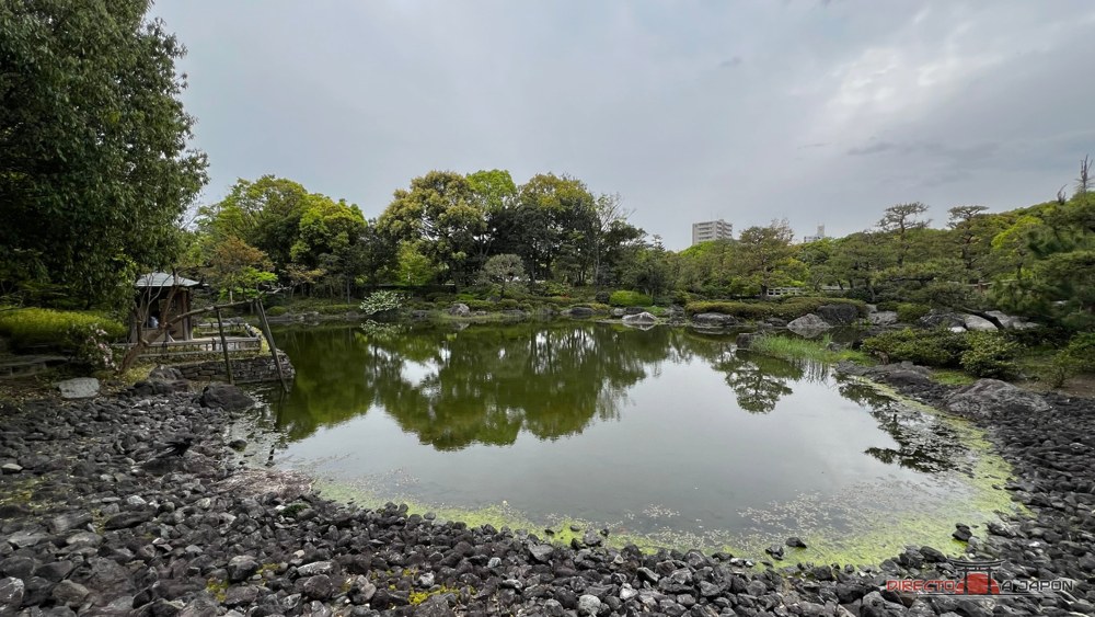 Estanque bordeado de rocas y árboles en Shirotori