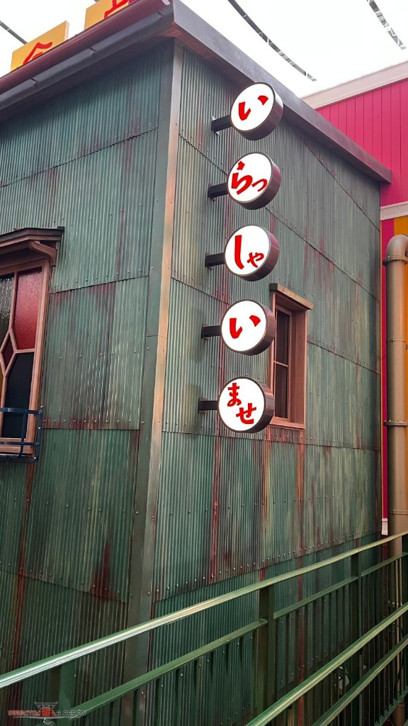 Fachada verde con ventanas y letreros japoneses dentro del Ghibli’s Grand Warehouse