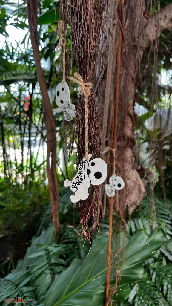 Figuras blancas de kodamas colgando de las raíces del gran árbol del Grand Warehouse