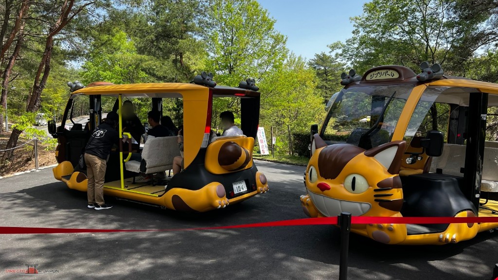 Dos microbuses eléctricos con forma de gatobús de Totoro estacionados en el Parque Ghibli