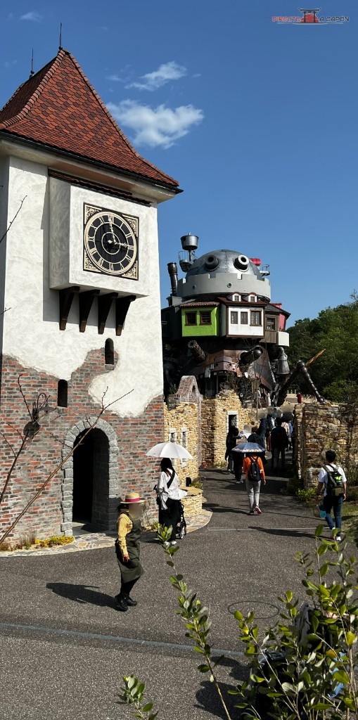 Vista del valle de las brujas del Parque Ghibli con la torre del reloj y el castillo de Howl al fondo