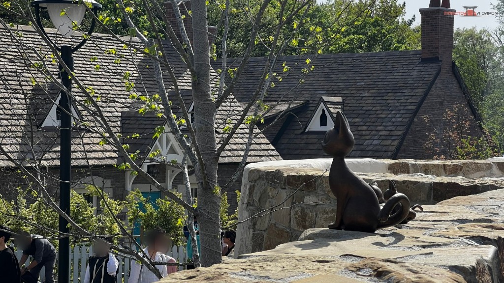 Estatua de bronce de un gato sentado sobre un muro de piedra en el valle de las brujas