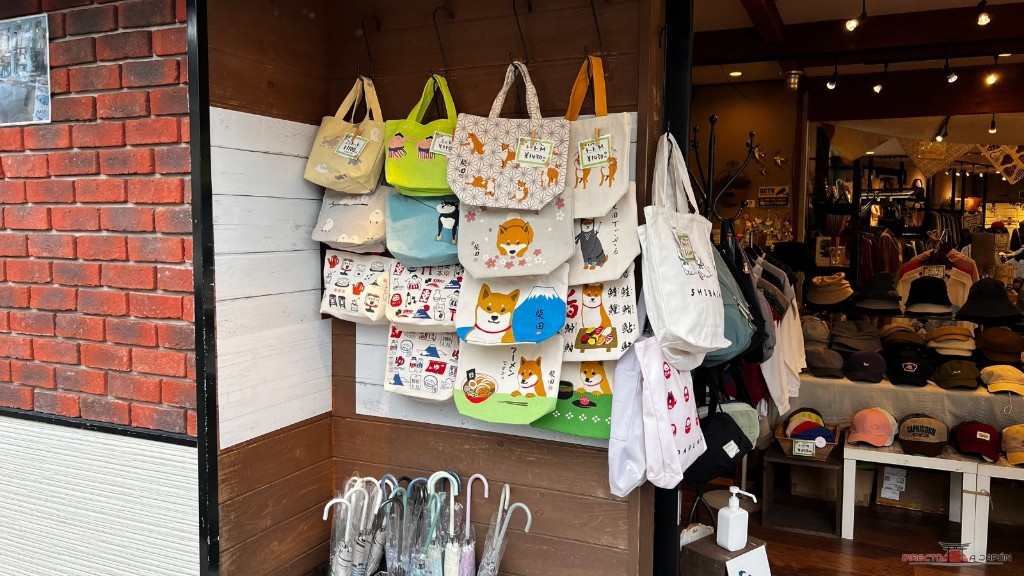 Bolsas de tela de shiba inu y gorras en una de las tiendas de la calle principal.