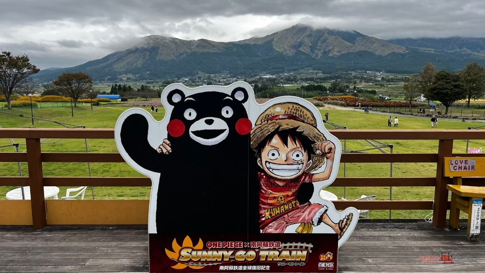 Kumamon y Luffy en el mirador del monte Aso, cerca de la estatua de Nami