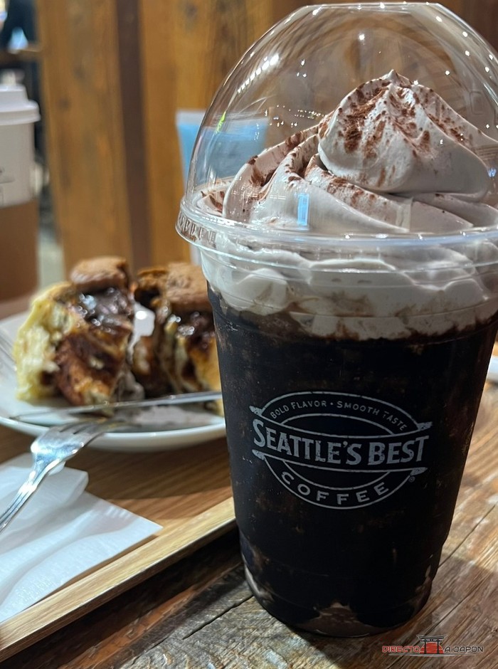 Frappé de Seattle's Best Coffee con nata y cacao junto a un rollo de canela de Cinnabon en la sucursal de la estación de Kumamoto