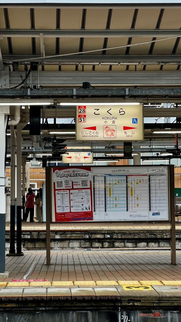 Cartel de la estación de Kokura, con el nombre en hiragana y en letras latinas, en el andén