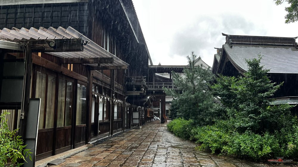 Calle de casas de madera junto al santuario Yasaka de Kokura bajo la lluvia, sin gente