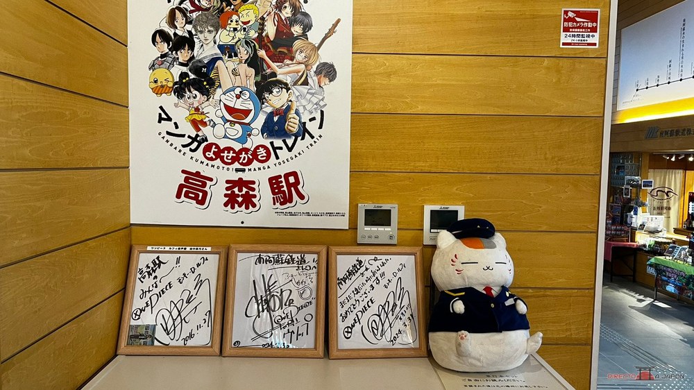 Póster de Manga Yosegaki Train, firmas y el peluche de Nyanko Sensei en la estación de Takamori