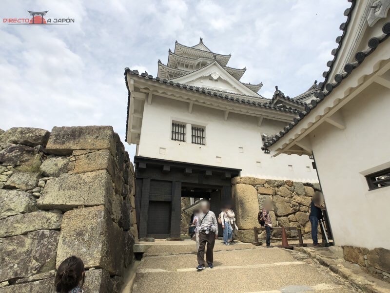 Puerta fortificada en el camino de subida a la torre del castillo de Himeji, encajada entre murallas de piedra ishigaki